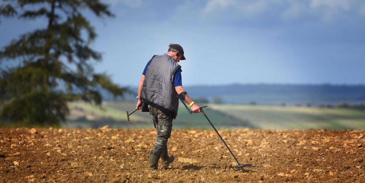 Man metal detecting in a field
